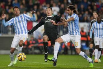 Real Madrid's Portuguese forward Cristiano Ronaldo (C) vies with Malaga's Brazilian defender Weligton (L) and defender Sergio Sanchez during the Spanish league football match Malaga CF vs Real Madrid CF at the Rosaleda stadium in Malaga on November 29, 2014.   AFP PHOTO/ JORGE GUERRERO