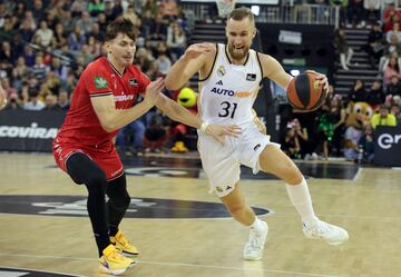 David Kramer, alero del Granada, intenta frenar la penetración del madridista Dzanan Musa.