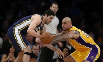 Robert Sacre de los Lakers en acción ante el turco Enes Kanter de los Jazz.