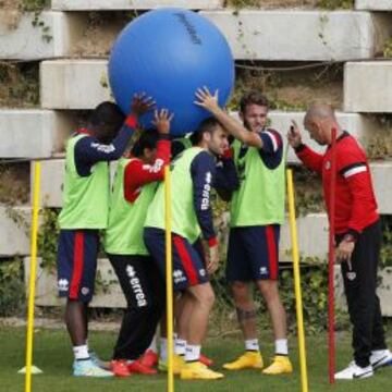 Paco explica a Fatau, Míchel, Leo y Quini, un ejercicio con un balón enorme.