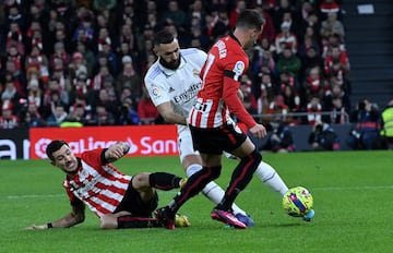 Karim Benzema entre los jugadores del Athletic Club, Yuri Berchiche y Álex Berenguer.