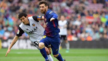 Barcelona's Argentinian forward Lionel Messi (R) vies with Valencia's Spanish midfielder Daniel Parejo during the Spanish league footbal match between FC Barcelona and Valencia CF at the Camp Nou stadium in Barcelona on April 14, 2018. / AFP PHO