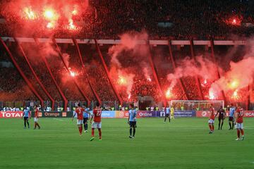 Al-Ahly supporters carry flares during the CAF Champions League final football match between Al-Ahly vs Wydad Casablanca at the Borg El Arab Stadium in Alexandria on October 28, 2017. 