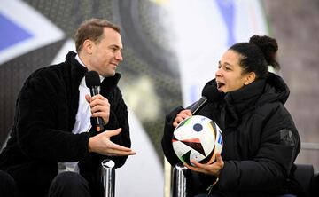 Celia Sasic (R), UEFA EURO 2024 tournament ambassador, holds the official ball as she talks with Manuel Neuer, goalkeeper of the German national football team, on November 15, 2023 at the Olympic Stadium in Berlin, Germany, during an event organised by sports equipment maker Adidas to present the official ball for the 2024 UEFA European Football Championship. (Photo by Tobias SCHWARZ / AFP)