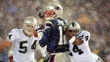 FOXBORO, UNITED STATES: New England Patriots quarterback Tom Brady (C) takes a hit from Charles Woodson (R) of the Oakland Raiders on a pass attempt in the last two minutes of the game in their AFC playoff 19 January 2002 in Foxboro, Massachusetts. The Patriots won 16-13 in overtime. AFP PHOTO/Matt CAMPBELL (Photo credit should read MATT CAMPBELL/AFP/Getty Images)