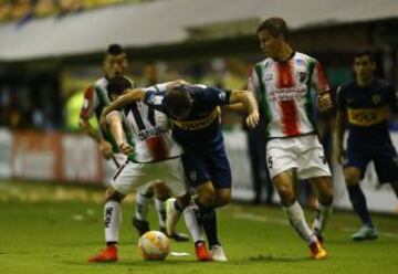 El jugador de Boca Esteban Carvajal, centro, disputa el balon con Agustin Farias de Palestino