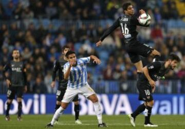 El defensa marroquí del Levante Issam El Adoua (c) salta por el balón junto a su compañero Rubén García (d), y el centrocampista del Málaga CF José Luis García "Recio" (i), durante el encuentro de la ida de octavos de final de la Copa del Rey que ambos equipos disputan esta noche en el estadio de La Rosaleda.