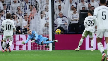 Real Madrid's Ukrainian goalkeeper #13 Andriy Lunin dives for the ball after Rayo Vallecano's Spanish midfielder #15 Gerard Gumbau Garriga had an effort on goal during the Spanish league football match between Real Madrid CF and Rayo Vallecano de Madrid at the Santiago Bernabeu stadium in Madrid on March 9, 2025. (Photo by Thomas COEX / AFP)