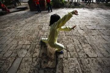 Un niño practica durante una sesión de entrenamiento de artes marciales "Wushu" a primera hora de la mañana en Katmandú (Nepal) hoy, miércoles 2 de octubre de 2013. Los expertos en artes marciales Dhan Kumar Ghising y Lessa Shrestha Ghising han organizado de manera conjunta sesiones de entrenamiento para 20 niños de entre cinco y seis años en la ciudad de Katmandú. La pareja de profesores se dedica a entrenar a niños para el arte marcial del wushu, un milenario deporte que hace parte de la herencia cultural china y que, tras una serie de ajustes reglamentarios busca de nuevo su posicionamiento global. El coste de estas clases es de 50 rupias (37 céntimos de euro) para las niñas y 100 rupias (74 céntimos de euro) para los niños.