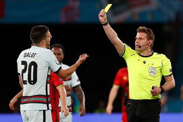 Felix Brych presents a yellow card to Portugal's defender Diogo Dalot during the UEFA EURO 2020 round of 16 football match between Belgium and Portugal.