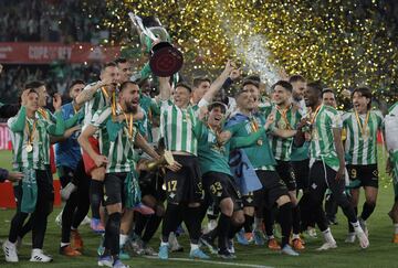 Los jugadores del Betis campeones de Copa celebran en el césped su triunfo.