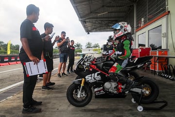 El circuito de Sepang acogió un campeonato de MiniGP que permite a los jóvenes corredores malayos de entre 8 y 13 años experimentar de primera mano lo que es ser un piloto profesional. En la imagen, los miembros del equipo ZK Racing, liderado por el expiloto Zulfahmi Khairudin, dan las últimas instrucciones antes de la carrera.