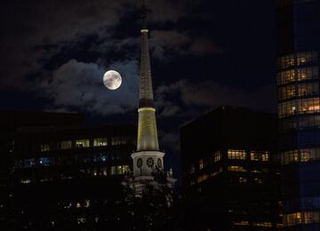 Una luna casi llena se eleva en el cielo sobre Boston, Massachusetts, Estados Unidos.