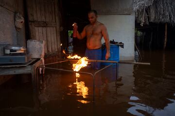 Un hombre enciende carbón para cocinar la cena en su casa inundada tras el paso del huracán Helene en Guanimar, provincia de Artemisa, Cuba.
