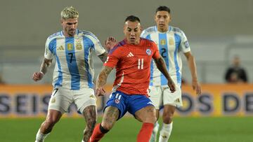Argentina's midfielder Rodrigo De Paul (L) and Chile's forward Eduardo Vargas fight for the ball during the 2026 FIFA World Cup South American qualifiers football match between Argentina and Chile at the Mas Monumental stadium in Buenos Aires on September 5, 2024. (Photo by JUAN MABROMATA / AFP)