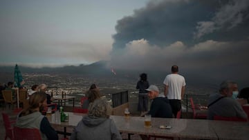 People observe the Cumbre Vieja volcano spews lava, ash and smoke, in Tijarafe, in the Canary Island of La Palma on October 5, 2021. - A new flow of highly liquid lava emerged from the volcano erupting in Spain's Canary islands on October 1, authorities said, as a huge magma shelf continues to build on the Atlantic ocean. (Photo by JORGE GUERRERO / AFP)
