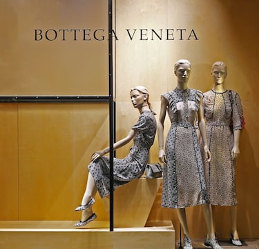 Marca de lujo italiana fundada en 1966 en Vicenza, Italia, por Michele Taddei y Renzo Zengiaro. Su nombre significa "Taller Veneciano", reflejando su enfoque artesanal en la moda. Desde sus inicios, la marca se especializó en artículos de cuero de alta calidad, desarrollando la técnica Intrecciato, un característico trenzado de cuero que se convirtió en su sello distintivo. A diferencia de otras marcas de lujo, Bottega Veneta evitó el uso de logotipos visibles, apostando por la discreción y la elegancia. En los años 2000, la marca fue adquirida por el grupo Kering, lo que impulsó su crecimiento internacional. Bajo la dirección de diseñadores como Tomas Maier y más recientemente Matthieu Blazy, Bottega Veneta ha evolucionado manteniendo su esencia minimalista y sofisticada. Hoy en día, es una de las firmas más exclusivas del mundo, con una fuerte presencia en moda, accesorios y fragancia.