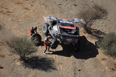 El piloto qatarí Nasser Al-Attiyah y su copiloto Edouard Boulanger reparan su coche tras un pinchazo durante la etapa 2B del 47º Rally Dakar.