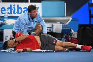 Kei Nishikori recibe un masaje m¨¦dico durante su partido contra Roger Federer.