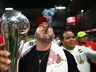 TOPSHOT - Toluca's Argentinian coach Antonio Mohamed smokes a cigar as he holds the trophy after a ceremony for the Mexican Champions following the Liga MX Clausura football tournament second leg final between Toluca and America at the Nemesio Diez stadium in Toluca de Lerdo, state of Mexico, Mexico on May 25, 2025. (Photo by CARL DE SOUZA / AFP)