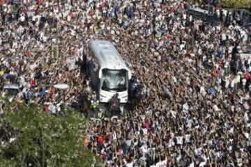 El autobús con los jugadores del Real Madrid llega al estadio Santiago Bernabéu rodeado de aficionados.