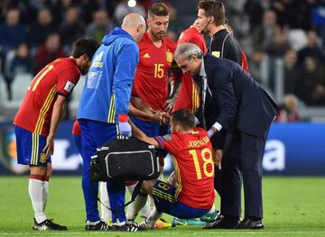 Spain's defender Jordi Alba (C bottom) gets medical assistance during the WC 2018 football qualification match between Italy and Spain on October 6, 2016 at the Juventus stadium in Turin /