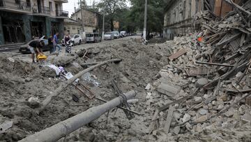 People stand next to the debris at the site of a residential building damaged during Russian missile strikes, amid Russia's attack on Ukraine, in Odesa, Ukraine July 23, 2023. REUTERS/Nina Liashonok
