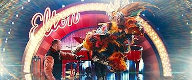 Elton John interpreta una versión satírica de sí mismo: es secuestrado por una villana que secuestra famosos y, en un giro inesperado, ayuda a los agentes Kingsman usando su voz y actitud característica. Participa en una escena de acción absurda llena de gags visuales y guiños a su estilo ochentero.