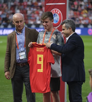 Homenaje a Enrique Castro 'Quini'. El nieto del jugador recibió una camiseta de la Selección española con el 9 y el nombre de 'Quini' a la espalda.