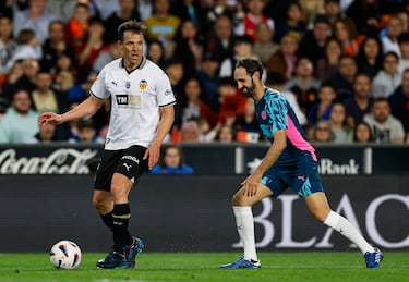 Carlos Marchena con el balón controlado espera la llegada de Juanfran Torres.