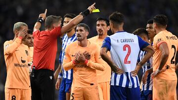 Atletico Madrid's Argentinian midfielder Rodrigo De Paul (C) argues as he receives a yellow card from Italian referee Daniele Orsato (2nd-L) during the UEFA Champions League 1st round Group B football match between FC Porto and Club Atletico de Madrid at the Dragao stadium in Porto, on November 1, 2022. (Photo by MIGUEL RIOPA / AFP)