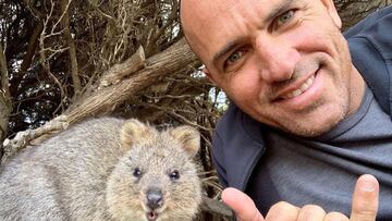 El 11 veces campeón del mundo de surf hace el gesto del shaka junto a un animal en Australia.