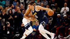 Nikola Jokic #15 of the Denver Nuggets drives to the basket while Karl-Anthony Towns #32 of the Minnesota Timberwolves defends