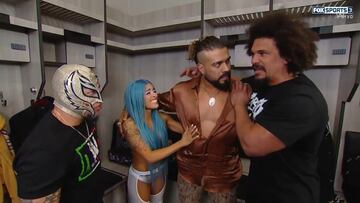 Andrade (centro), se abraza con Carlito (der) y Zelina Vega (izq) ante los ojos de Rey Mysterio.