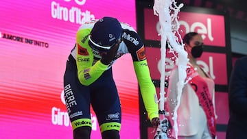 El ciclista eritreo Biniam Girmay se lleva la mano al ojo tras el golpe que recibi&oacute; al descorchar el champ&aacute;n en el podio como ganador de la d&eacute;cima etapa del Giro de Italia en Jesi.