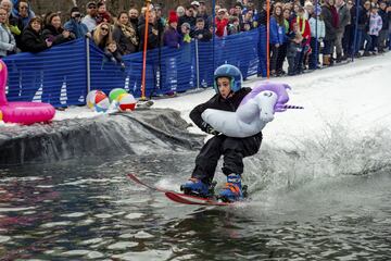Un joven esquiador con un flotador de un unicornio se desliza sobre el agua durante una peculiar competici¨®n en Westminster, Massachusetts. La prueba consiste en descender esquiando la monta?a Wachusett para terminar en un estanque artificial. Gana quien m¨¢s tiempo permanezca sobre la superficie del agua antes de hundirse.