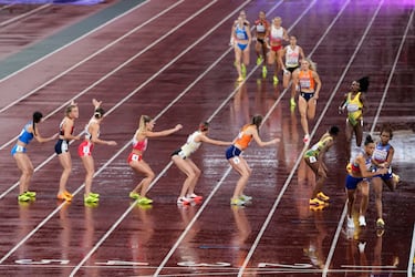 La estadounidense Sydney McLaughlin-Levrone recibe el testigo de manos de Aaliyah Butler en la final femenina de relevos 4 x 400 metros del Campeonato Mundial de Atletismo, bajo la lluvia en Tokio.