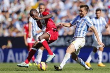 El delantero francés del Rayo Vallecano, Gaël Kakuta (i), lintenta controlar el balón ante el centrocampista del Málaga, Ignacio Camacho (d), durante el encuentro de la novena jornada de Liga de Primera División que los dos equipos disputan en el estadio de La Rosaleda, en Málaga. 