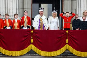 El rey Carlos y la reina Camila saludan a los asistentes desde el balcón del Palacio de Buckingham.