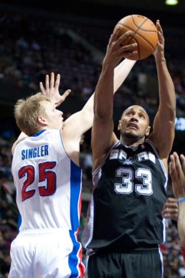 Boris Diaw, de los Spurs, entra a canasta superando a Kyle Singler, jugador de los Pistons