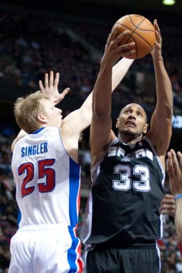 Boris Diaw, de los Spurs, entra a canasta superando a Kyle Singler, jugador de los Pistons