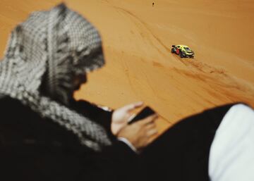 Un espectador repasa su móvil mientras transcurre la séptima etapa del Rally Dakar 2022.