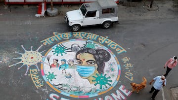 A man walks his dog past a graffiti on a road to create awareness about staying at home during an extended nationwide lockdown to slow the spreading of coronavirus disease (COVID-19) in Lucknow, India, April 22, 2020. REUTERS/Pawan Kumar