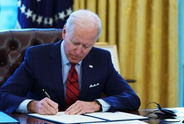 US President Joe Biden signs executive orders on health care, in the Oval Office of the White House in Washington, DC, on January 28, 2021.