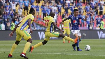 Santiago Montoya ante la marca de un rival durante el partido entre Millonarios y Huila por Liga &Aacute;guila.