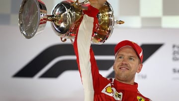 BAHRAIN, BAHRAIN - APRIL 08: Race winner Sebastian Vettel of Germany and Ferrari celebrates on the podium during the Bahrain Formula One Grand Prix at Bahrain International Circuit on April 8, 2018 in Bahrain, Bahrain. (Photo by Clive Mason/Getty Images