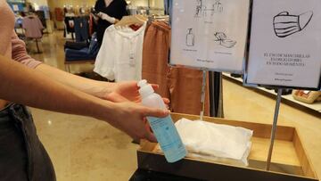 Una mujer usa el gel hidroalcohólico en sus manos.