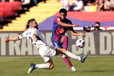 El jugador del Real Madrid, Carvajal, trata de frenar al jugador del Barcelona, Balde. 
 