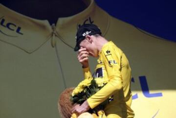 Chris Froome se seca las lágrimas subiendo al podio.