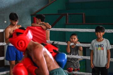 Un par de ni?os observan a dos j¨®venes que est¨¢n entrenando en el ring.